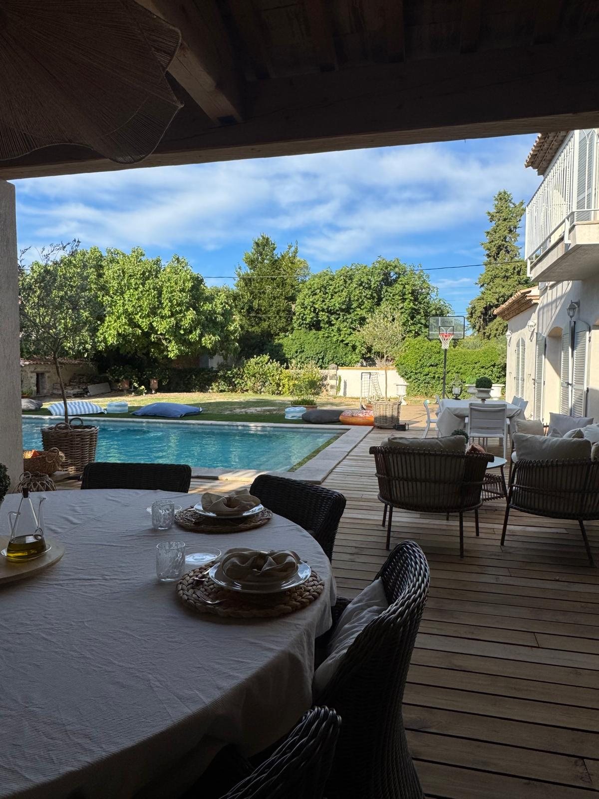 Une table dressée sur la terrasse, face à la piscine